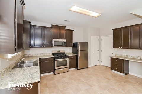A kitchen with brown cabinets and a stove top oven.