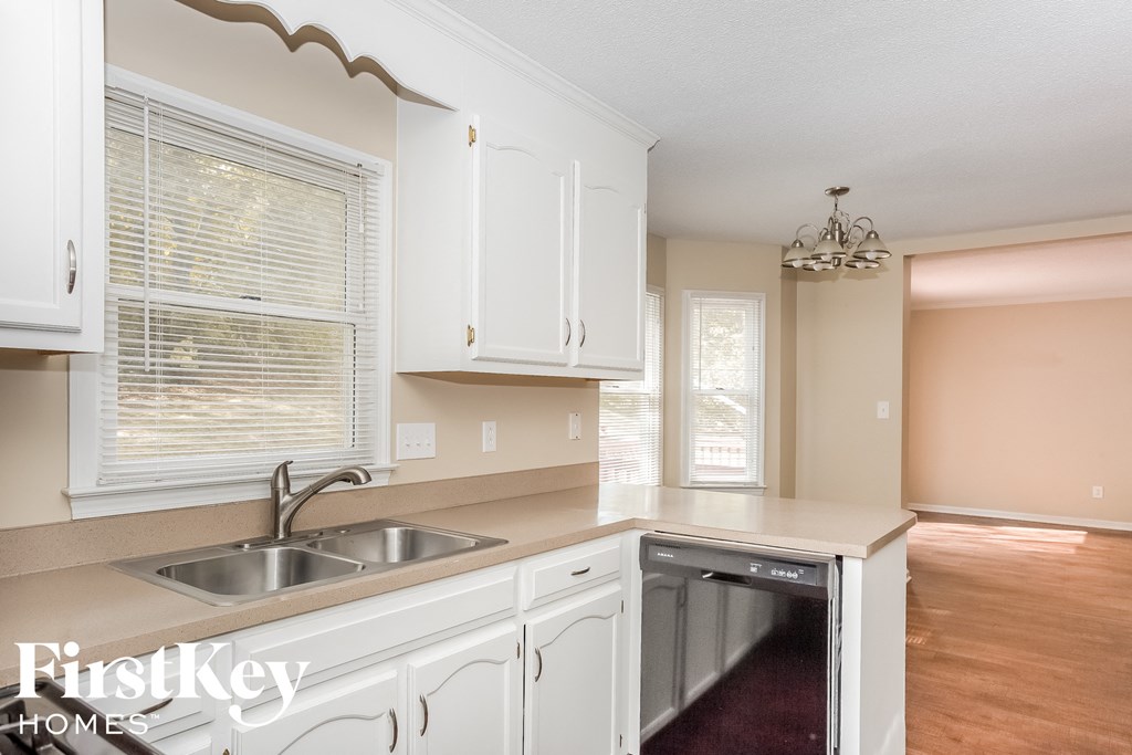 a kitchen with white cabinets and a sink and a dishwasher