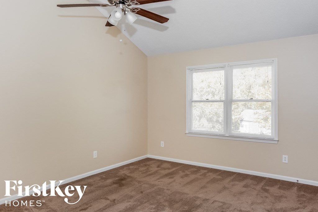 a bedroom with a ceiling fan and a window