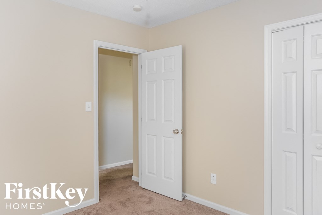 a bedroom with two white doors and a door to a closet