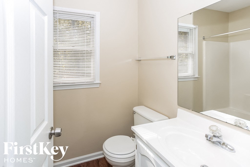 a bathroom with a toilet and a sink and a mirror
