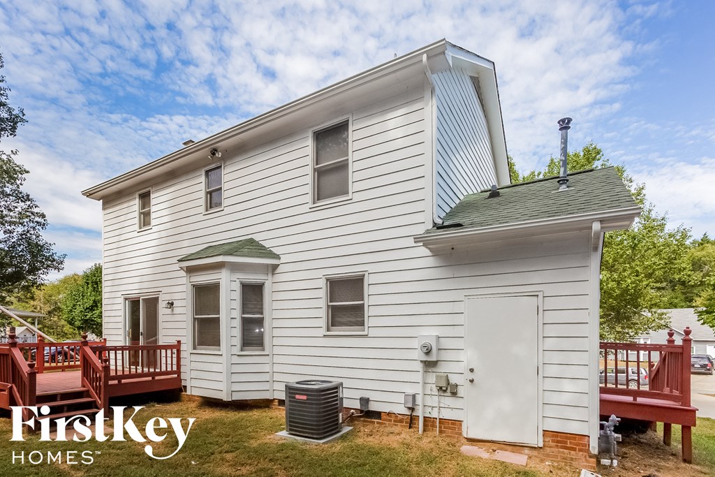 the front of a white house with a red deck