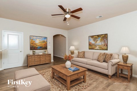A living room with a couch, two end tables, and a painting on the wall.