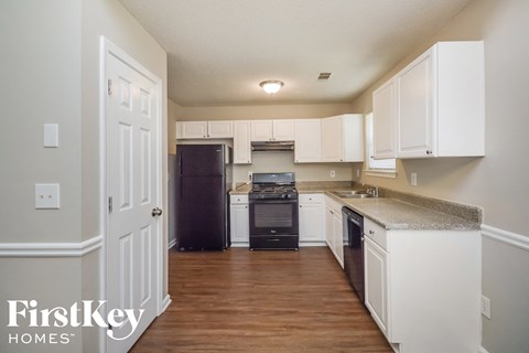a kitchen with white cabinets and a black stove and refrigerator