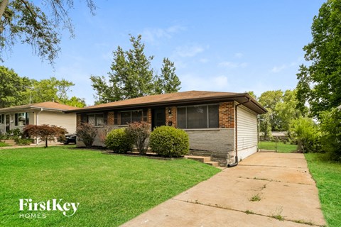 a bungalow with a lawn and a sidewalk