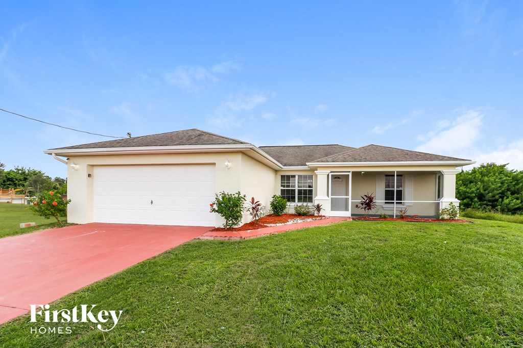 a home with a lawn and a white garage door