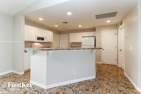 a kitchen with white cabinets and a granite counter top