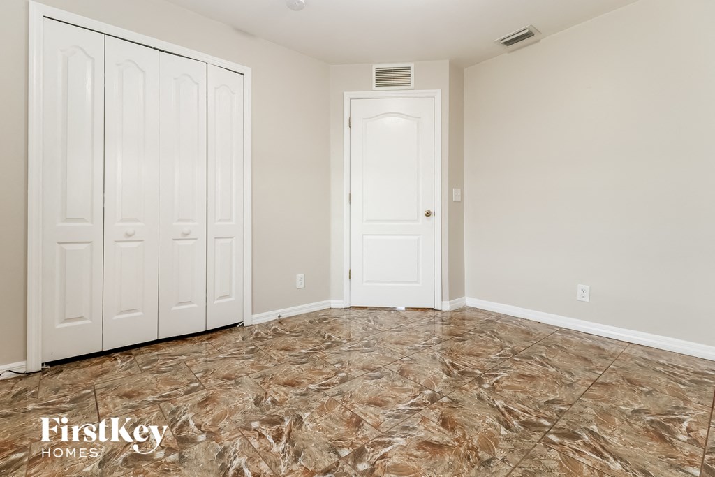 a bedroom with two closets and a tiled floor