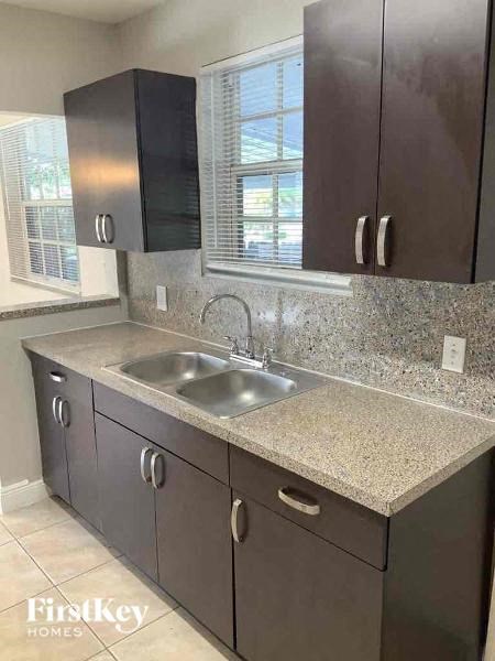 A kitchen with brown cabinets and a granite countertop.