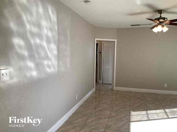 A room with a ceiling fan and a door leading to another room.