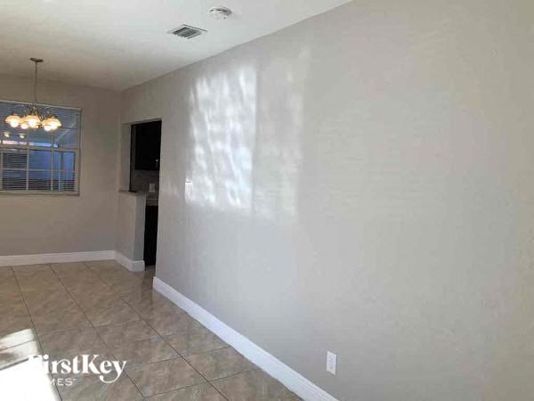 A room with a tiled floor and a window with blinds.