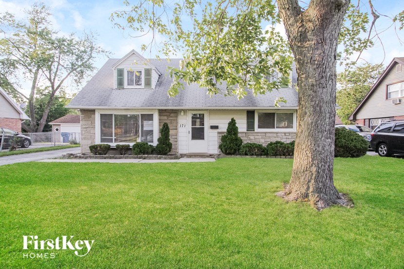 a white house with a tree in the front yard