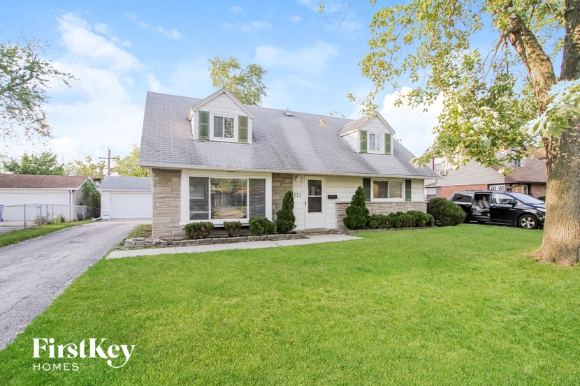 a home with a lawn and a car parked in front of it