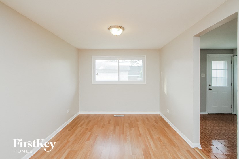 an empty living room with wood floors and a white door
