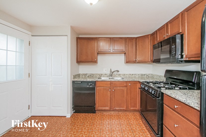 a kitchen with wood cabinets and black appliances