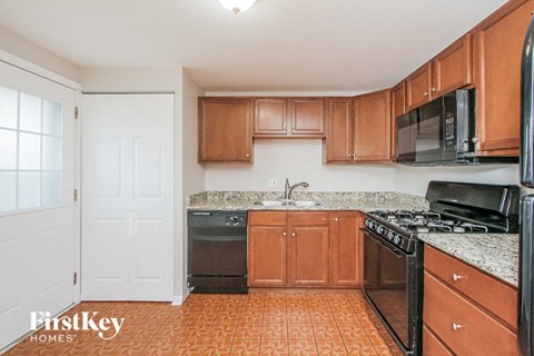 a kitchen with wood cabinets and black appliances