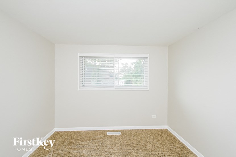 a empty room with a window and a carpet