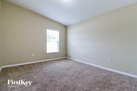 a bedroom with carpet and a window