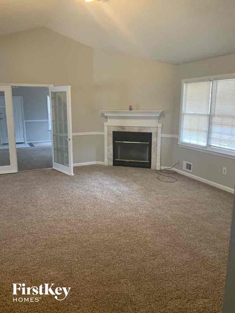 a living room with a carpeted floor and a fireplace