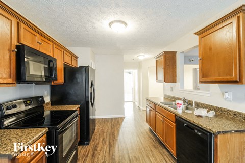 a kitchen with black appliances and wooden cabinets
