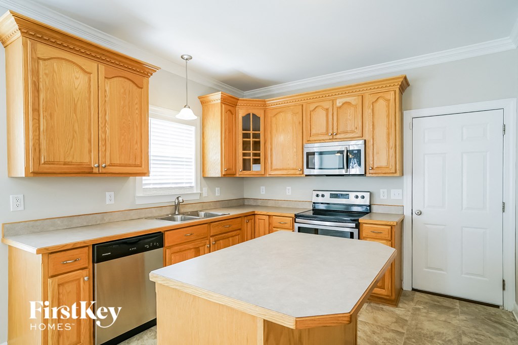 a kitchen with wooden cabinets and a white counter top