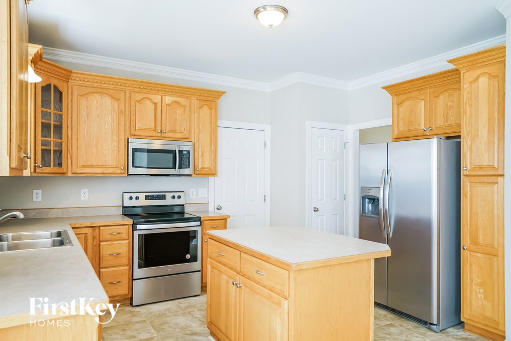 a kitchen with wooden cabinets and stainless steel appliances