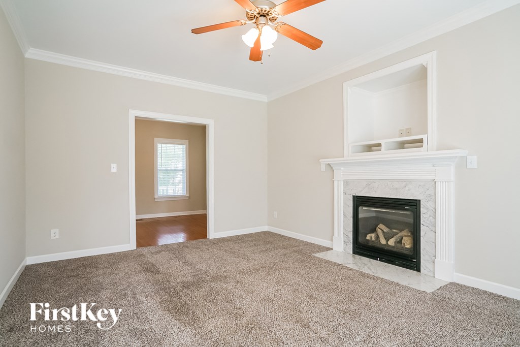 a living room with a fireplace and a ceiling fan
