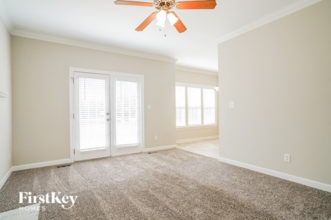 a living room with carpet and a ceiling fan
