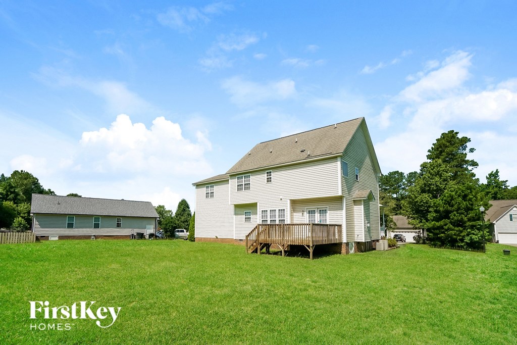 a white house with a wooden deck on a hill
