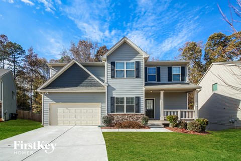 a blue house with a white garage door and a lawn