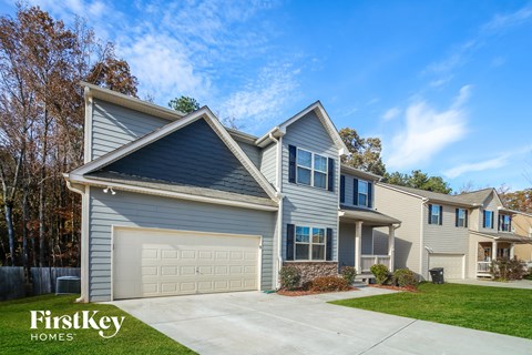 a blue house with a garage door and a lawn