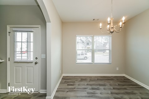 the dining room of a new home with a white door and window