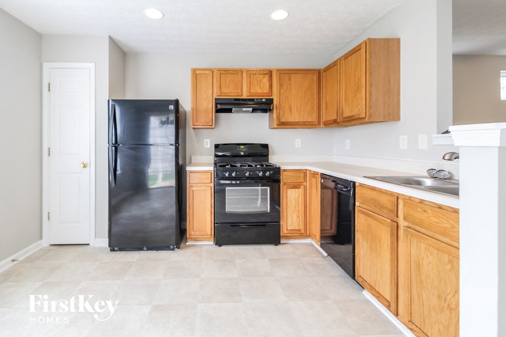 a kitchen with wooden cabinets and black appliances
