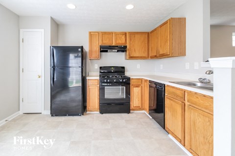 a kitchen with wooden cabinets and black appliances