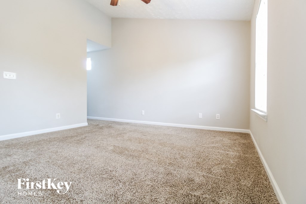 an empty room with a carpeted floor and a white wall