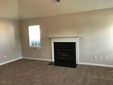 a living room with a fireplace and a window