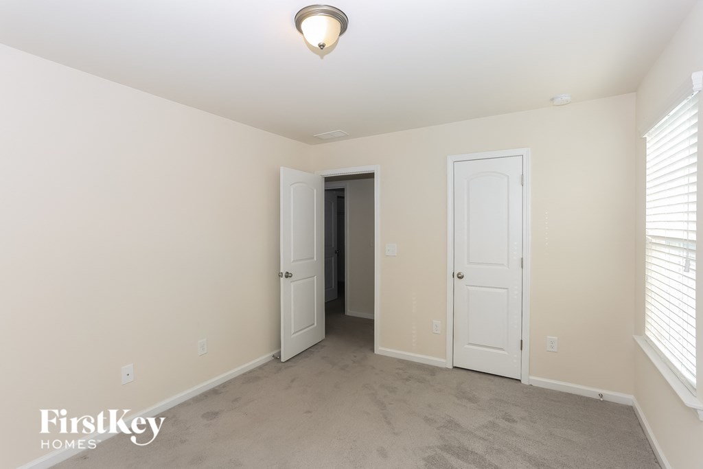 A room with two doors and a carpet floor.