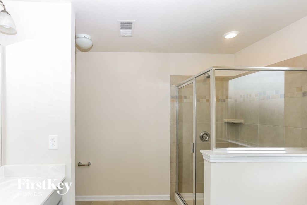 A white bathroom with a glass shower door.