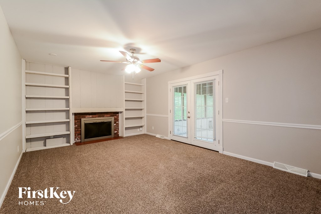A room with a fireplace and a ceiling fan.