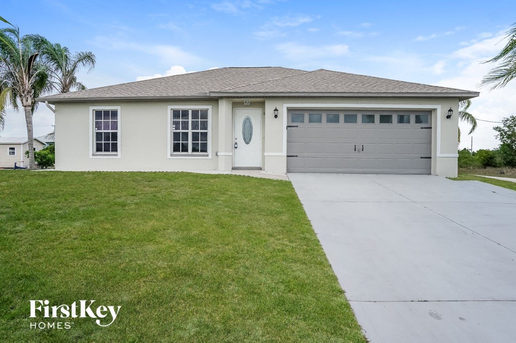 A house with a garage door and a driveway in front of it.