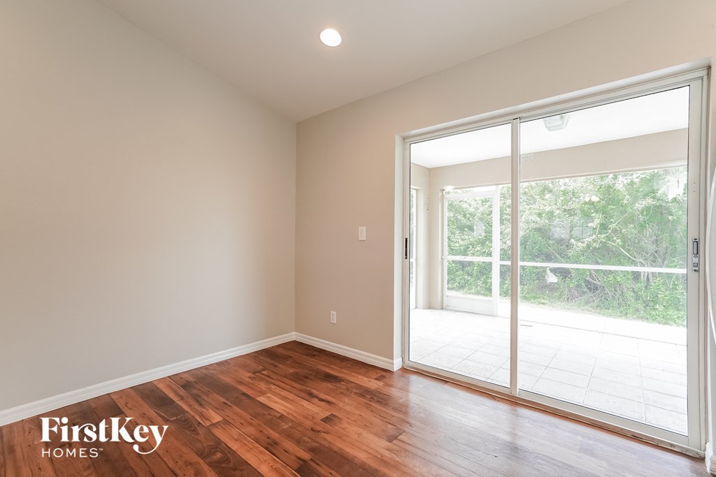 A room with a sliding glass door leading to a balcony.
