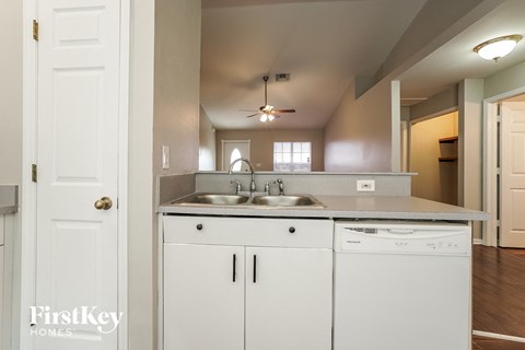 A white kitchen with a sink and a dishwasher.