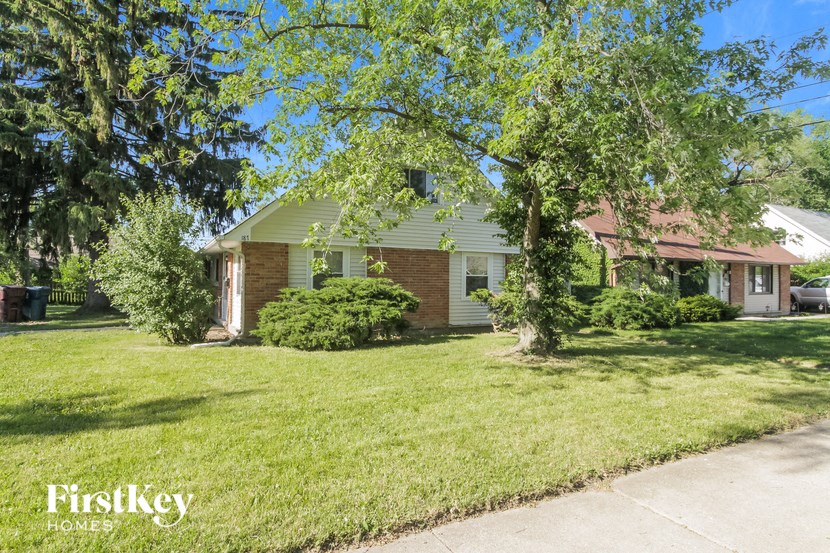 a house with a lawn and trees in front of it