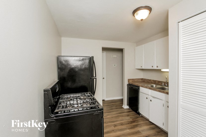 a kitchen with white cabinets and a black stove and refrigerator