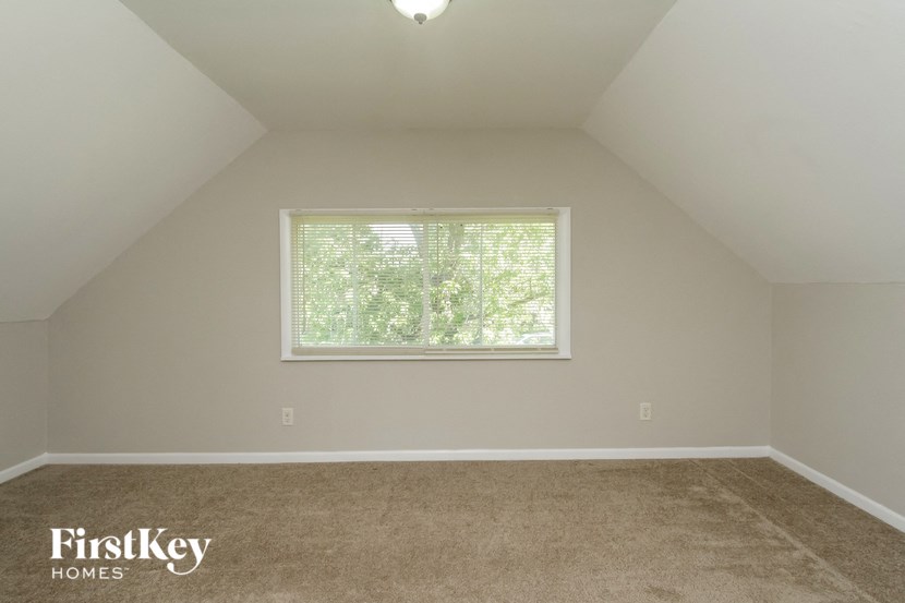 the upstairs loft has a large window and carpeting