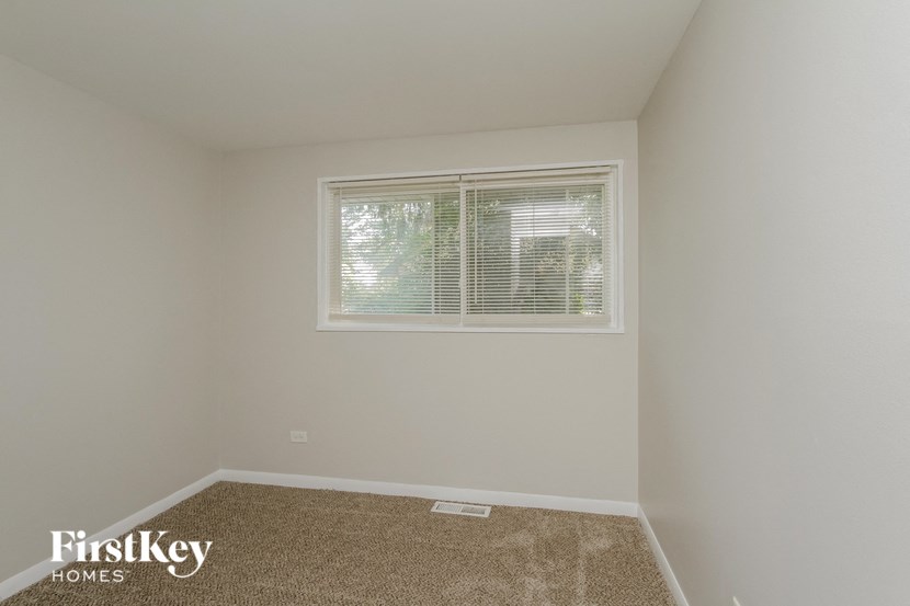 a small room with a window and a carpet