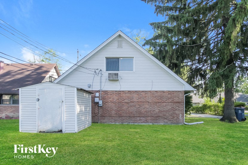 a small brick house with a garage and a tree