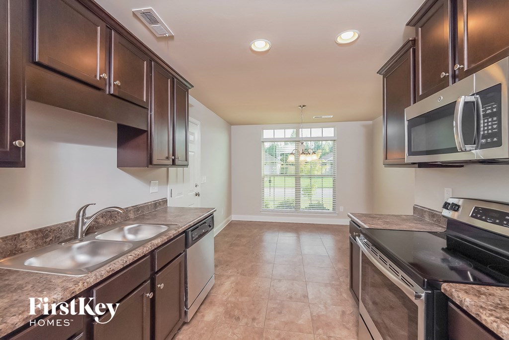 a kitchen with wooden cabinets and stainless steel appliances and a window