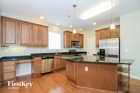 A kitchen with wooden cabinets and granite countertops.