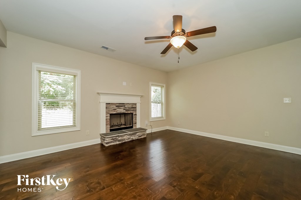 a living room with a ceiling fan and a fireplace